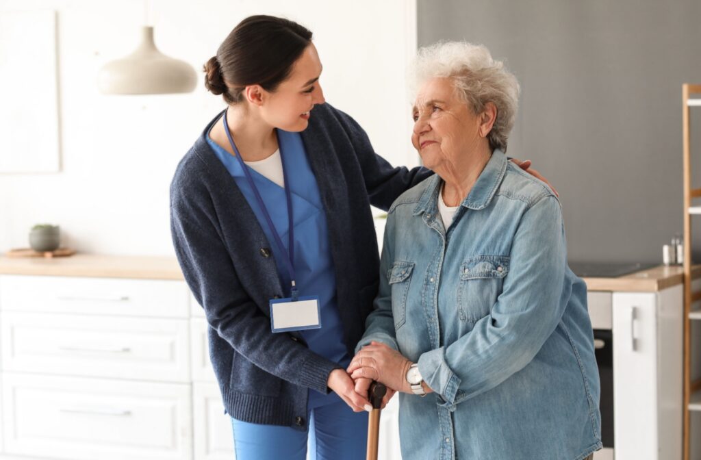 A caregiver checking on an older adult in senior living after an alert from fall detection technology.